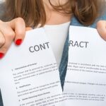 Business woman tearing contract in office - breaking contract